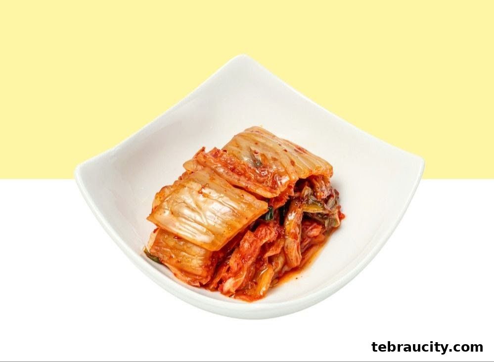 A white bowl filled with spicy Korean kimchi against a yellow and white background.