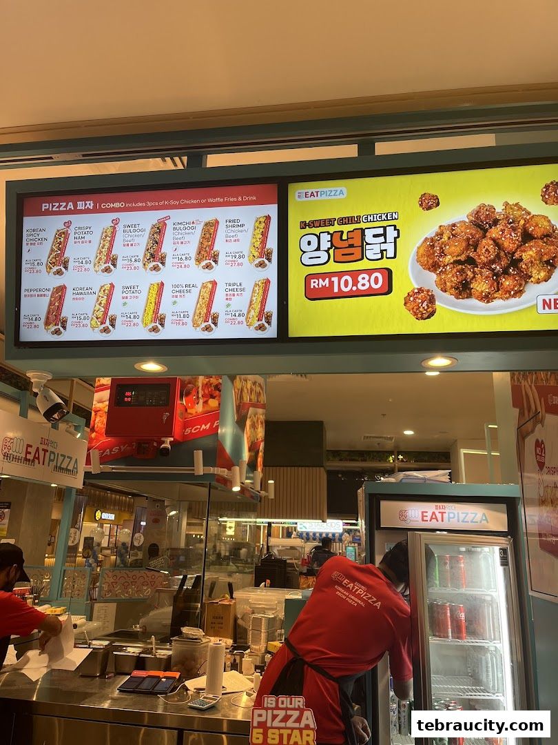 A digital menu board displaying various pizza and chicken options from Eat Pizza.