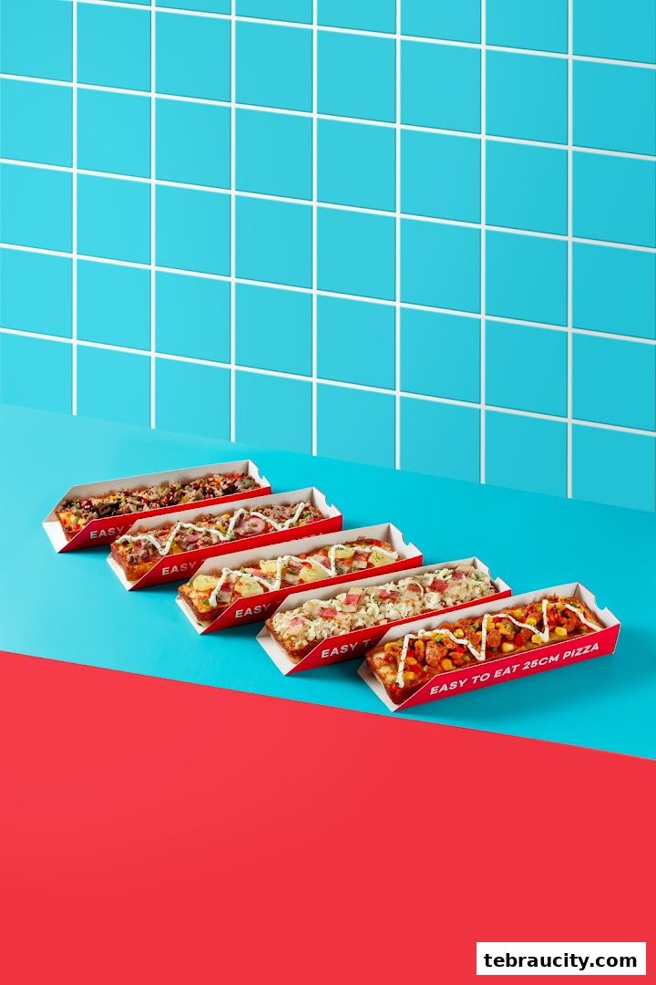 Five rectangular pizzas with various toppings are displayed against a blue tiled background.