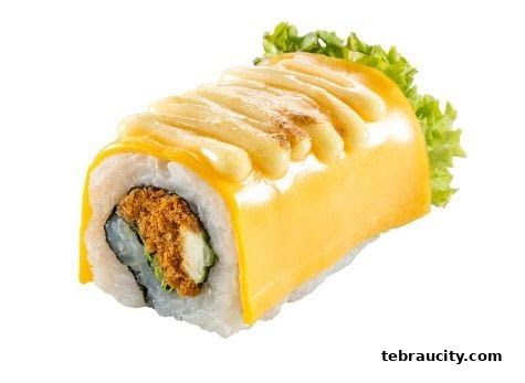 A delicious sushi roll topped with cheese and mayonnaise, garnished with lettuce.
