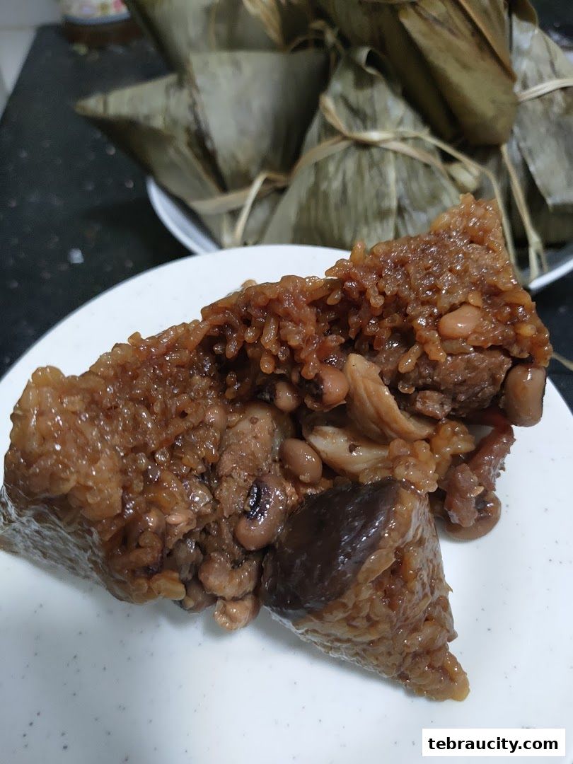 A close-up of a delicious, savory rice dumpling filled with meat and beans.