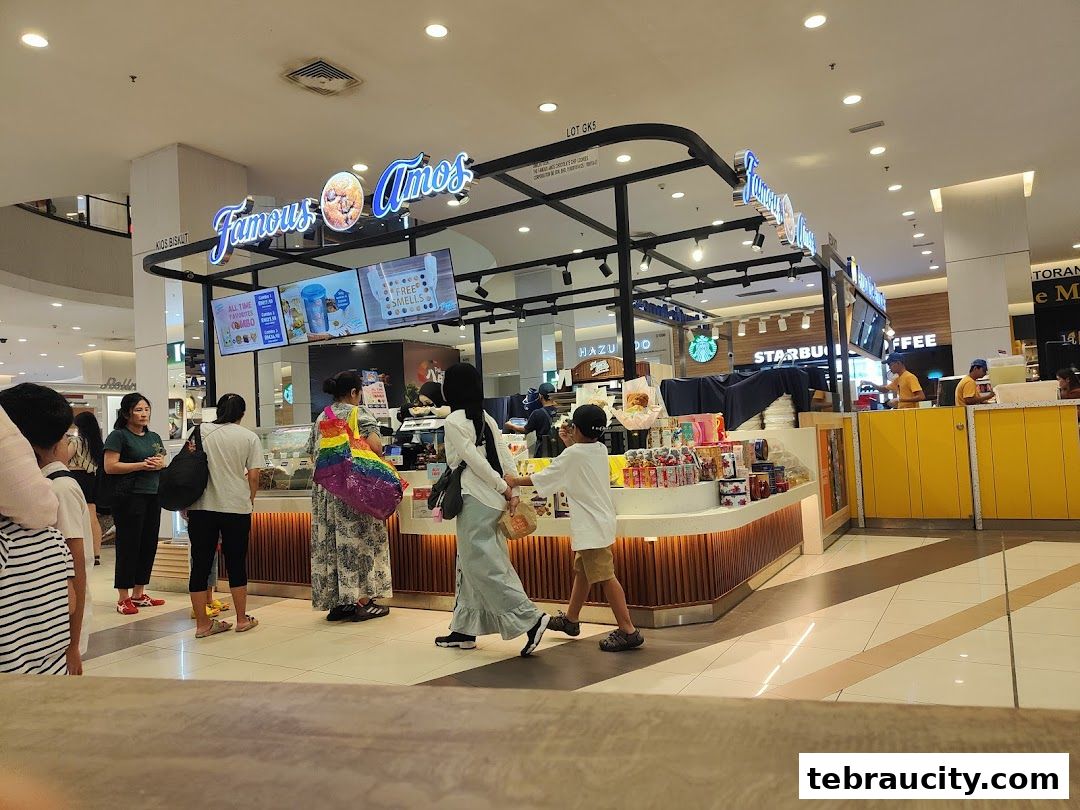 A Famous Amos cookie store with customers queuing and a Starbucks in the background.