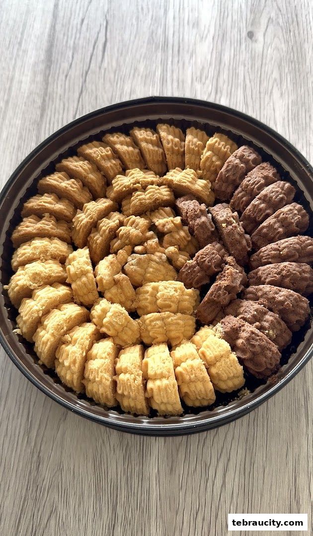 A round platter filled with two types of intricately shaped cookies, arranged in a spiral pattern.