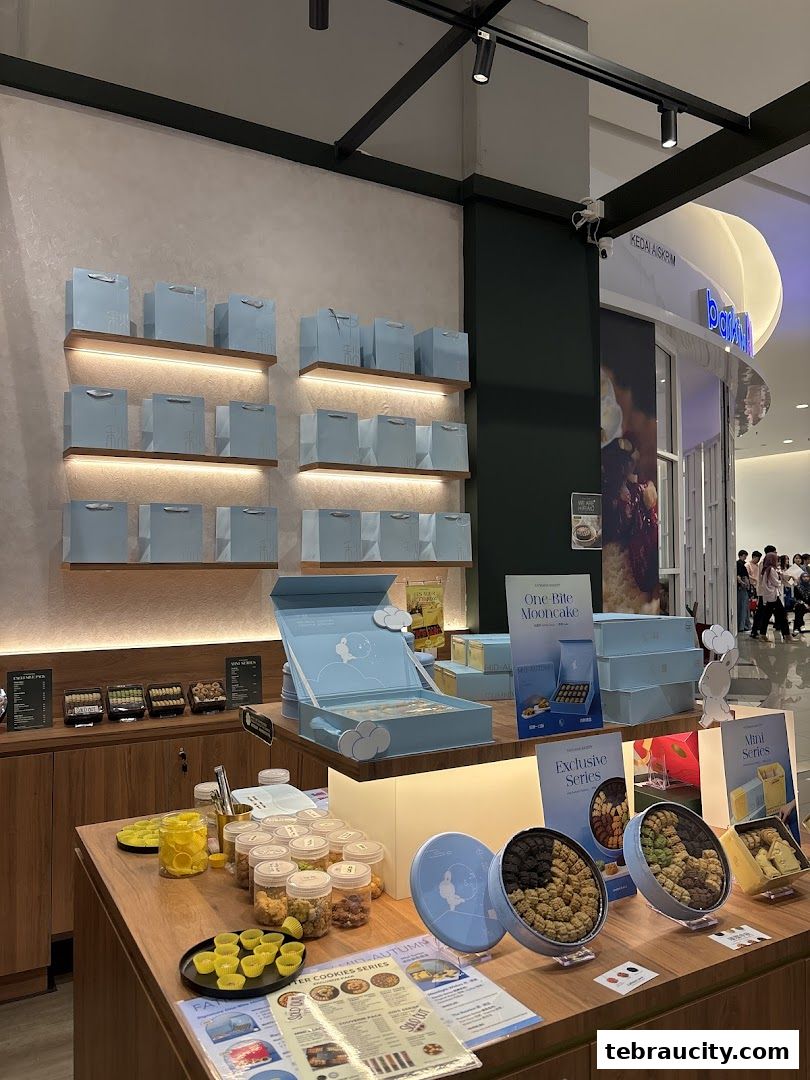 A bakery display featuring mooncakes and cookies in attractive packaging and jars.