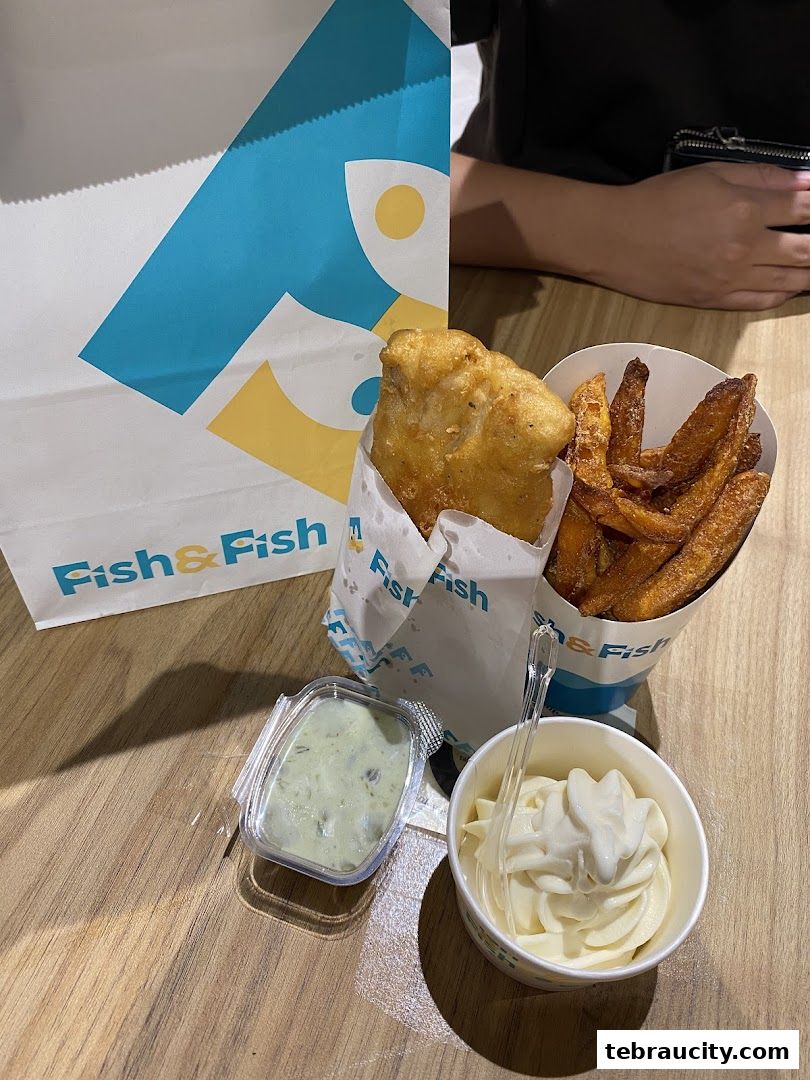 A delicious meal from Fish & Fish featuring crispy fish, fries, sauce, and soft serve ice cream.