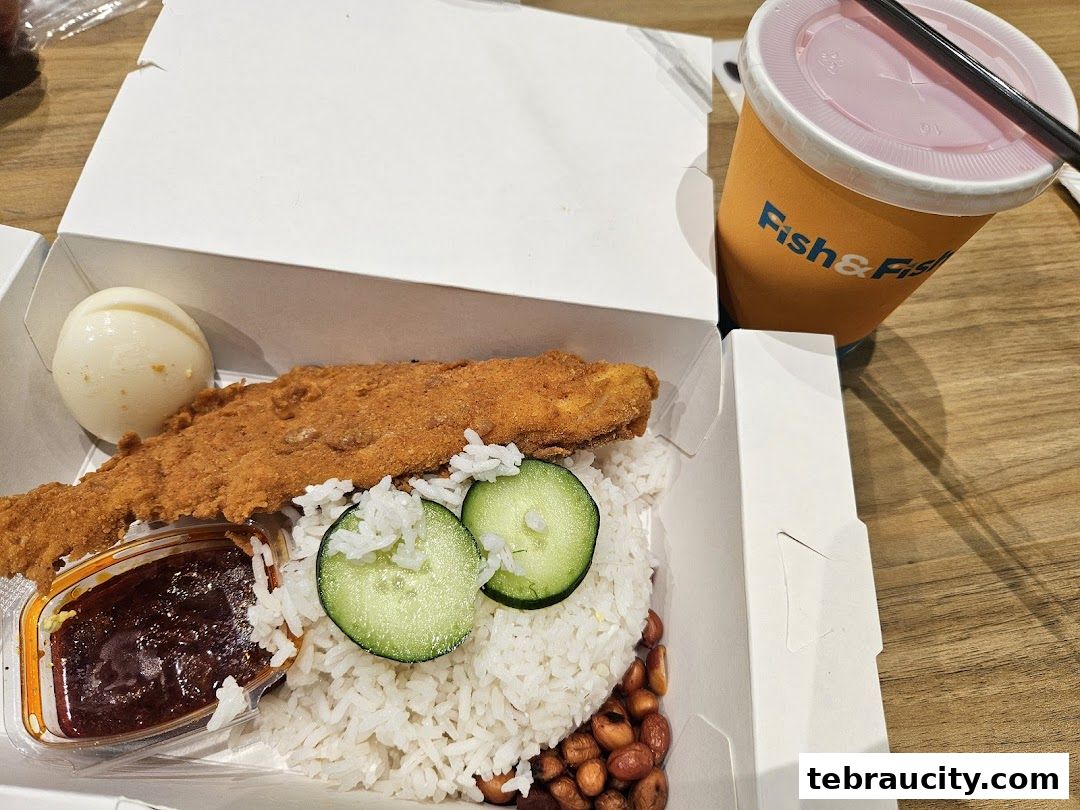 A delicious meal from Fish & Fish featuring fried fish, rice, egg, and sambal with a drink.
