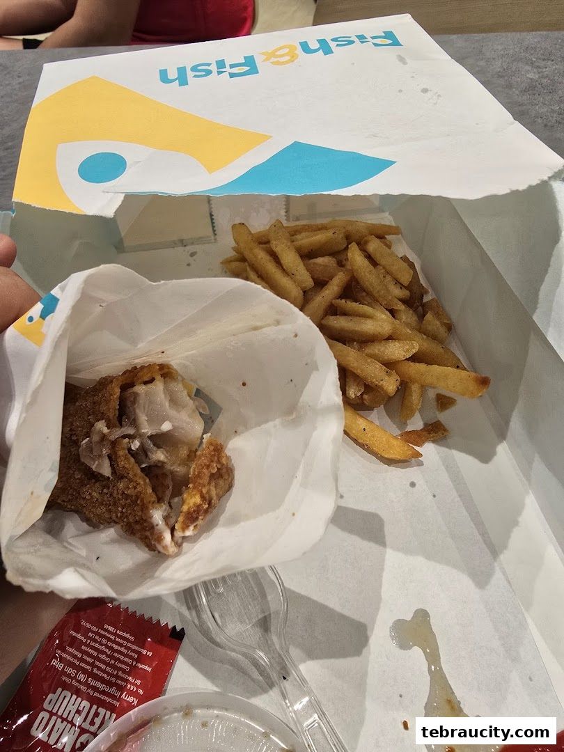 A paper bag from Fish & Fish containing fried fish and french fries.