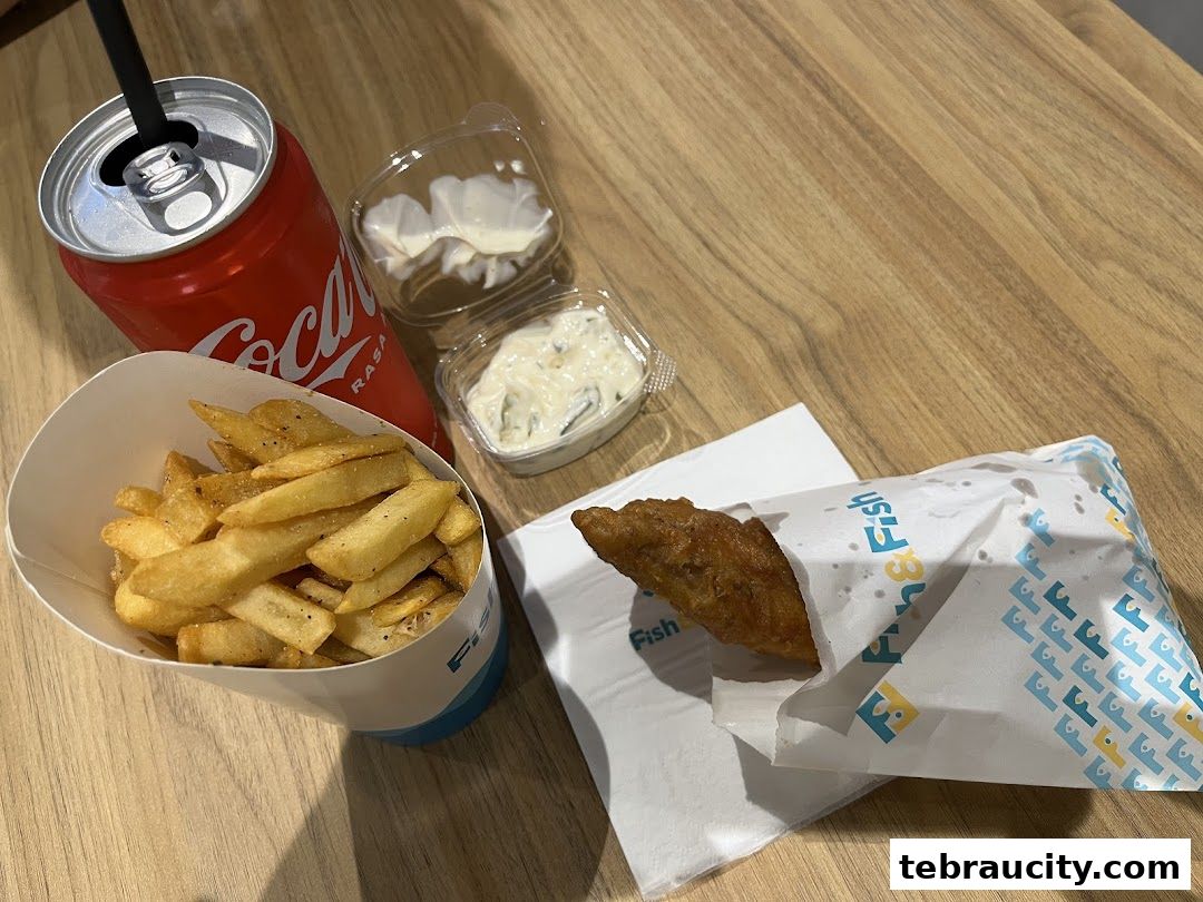 A meal from Fish & Fish featuring fried fish, fries, dipping sauces, and a can of Coca-Cola.