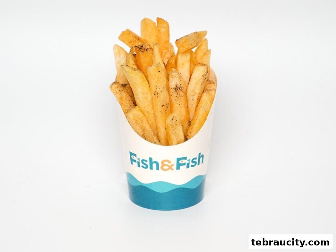 A cup of seasoned french fries with the 'Fish & Fish' logo on a white background.