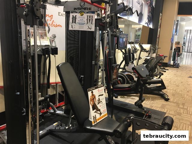 A variety of fitness equipment, including a multi-gym and exercise bikes, displayed in a retail store.