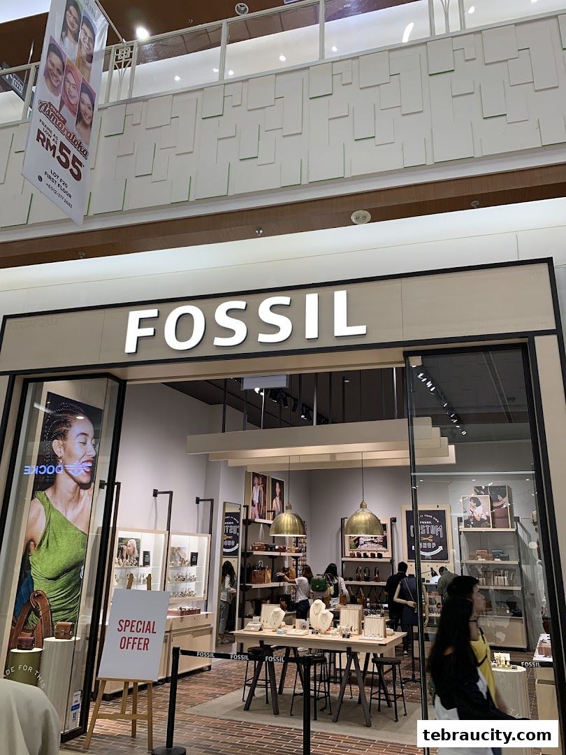 The exterior of a Fossil store with its prominent signage and displays of watches and bags.