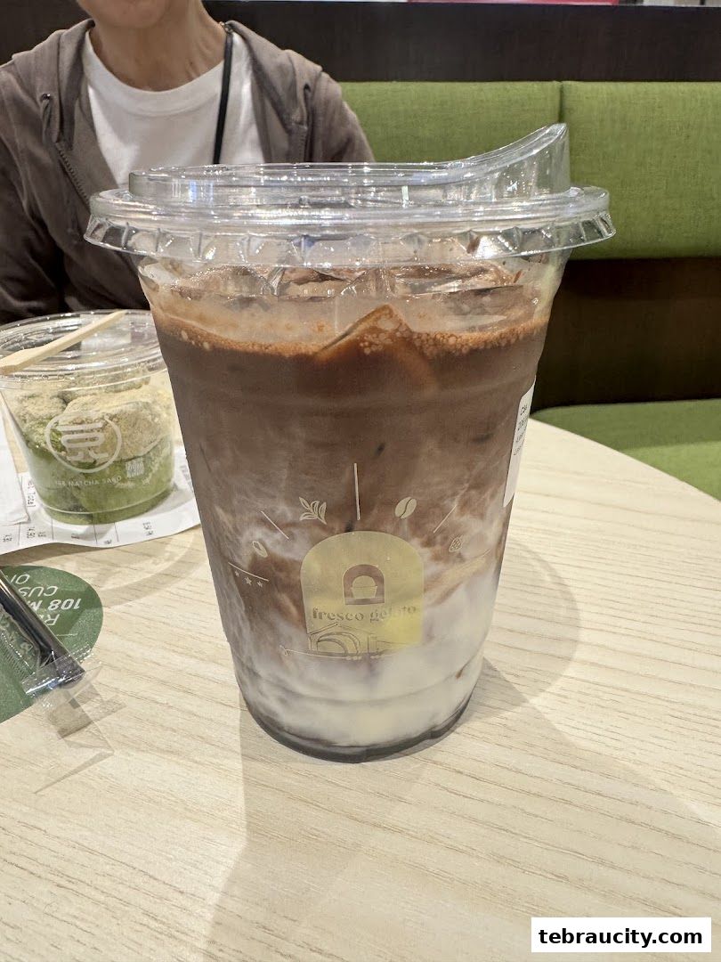 A close-up of a refreshing chocolate gelato drink with ice and milk.