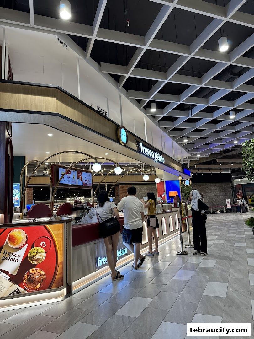 Customers ordering gelato at a Fresco Gelato counter in a mall.