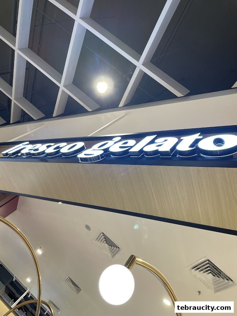 A close-up shot of the illuminated 'Fresco Gelato' sign inside a mall.