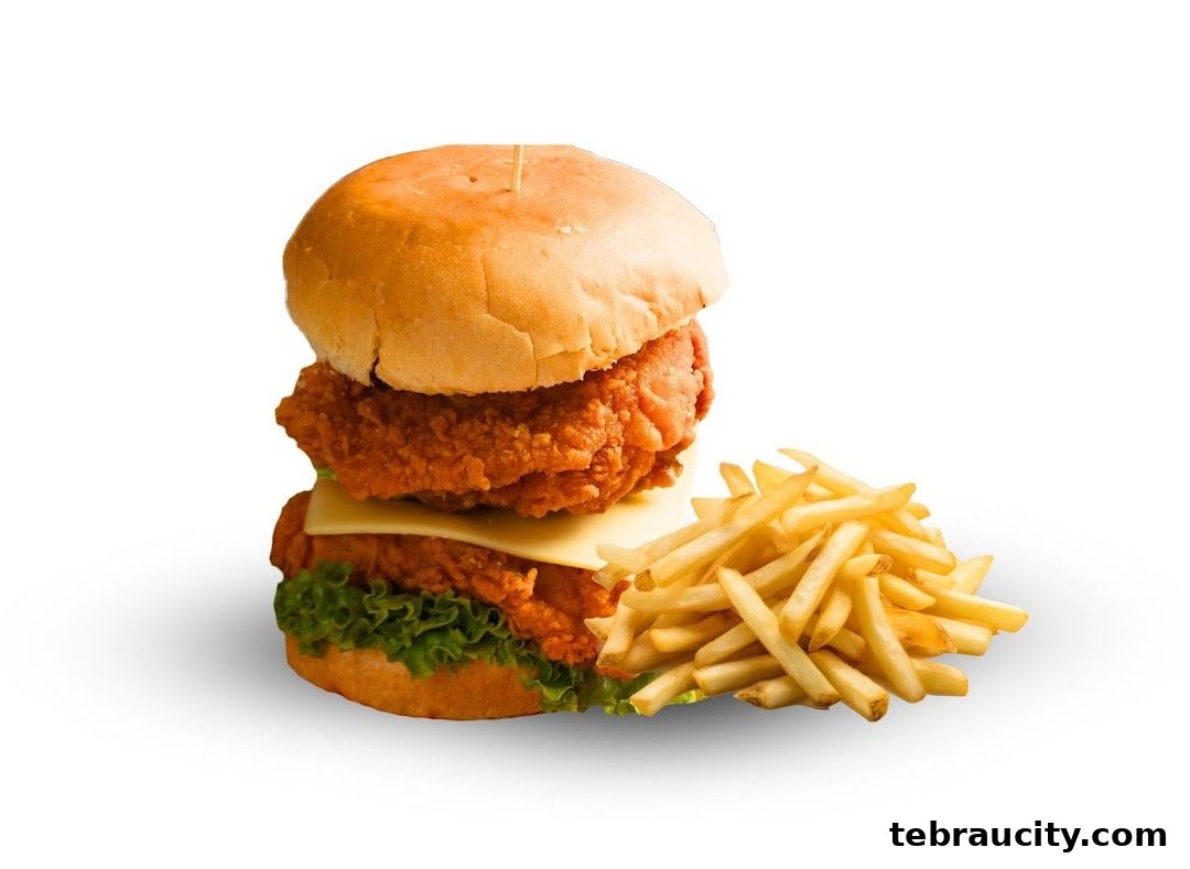 A delicious double chicken burger with cheese and fries, presented against a white background.