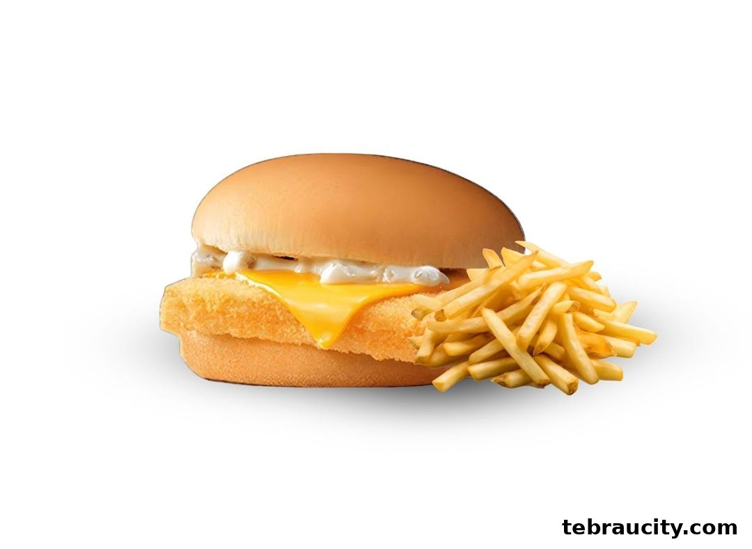 A delicious fish burger with melted cheese and a side of crispy french fries.