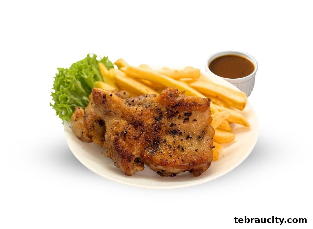 A plate of grilled chicken with fries, lettuce, and a side of gravy.