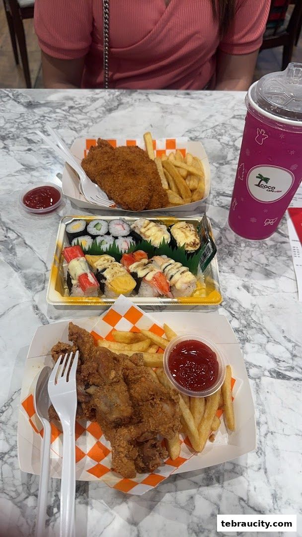 Two servings of fried chicken and fries, and a sushi platter with a drink.