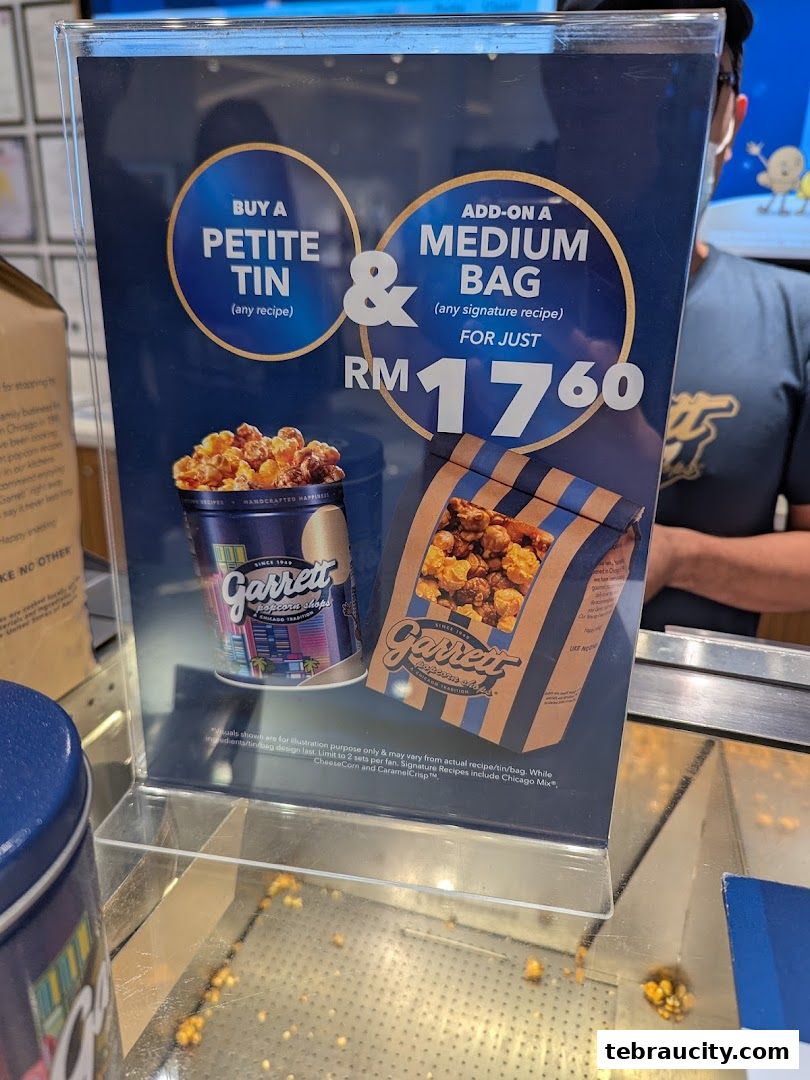 A promotional sign for Garrett Popcorn Shops offering a deal on a petite tin and medium bag.