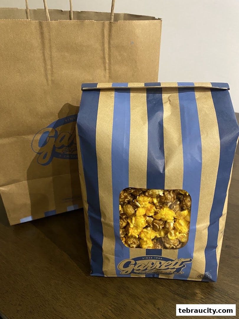 A bag of Garrett Popcorn with a shopping bag in the background.