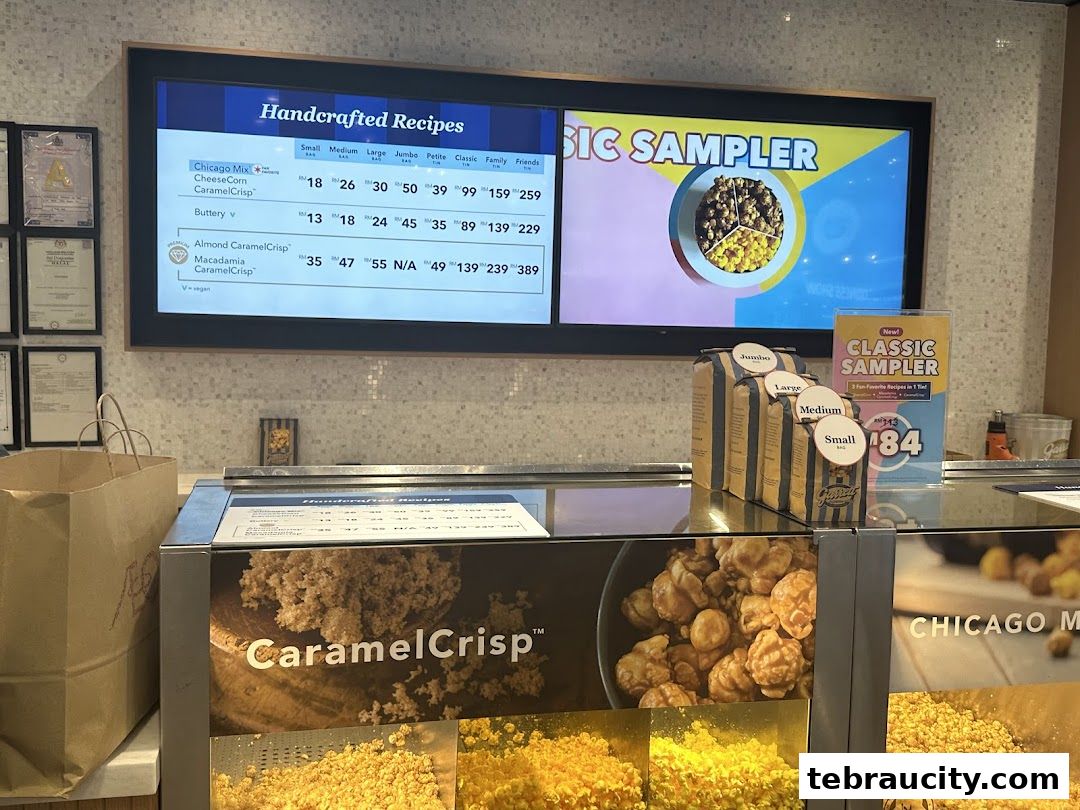 A digital menu board displaying various popcorn flavors and sizes with prices.