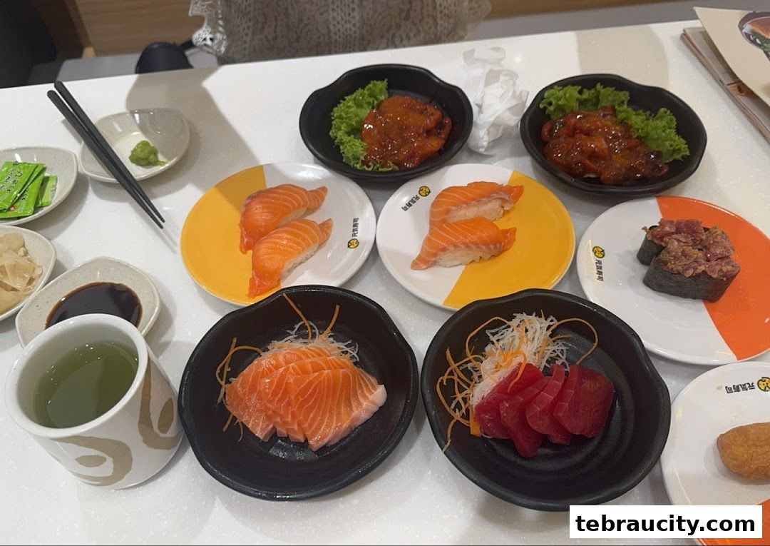 A table full of delicious sushi and sashimi dishes, with green tea and condiments.