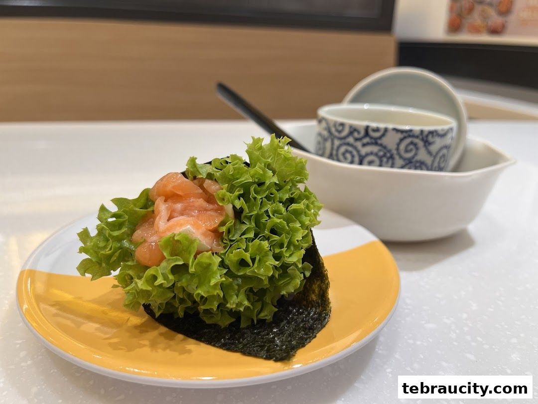 A close-up of a salmon temaki sushi roll with fresh lettuce on a yellow and white plate.