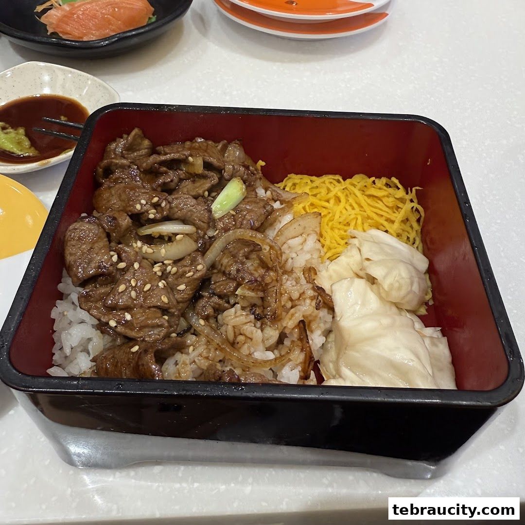 A close-up of a delicious beef and rice bowl with shredded egg and cabbage.