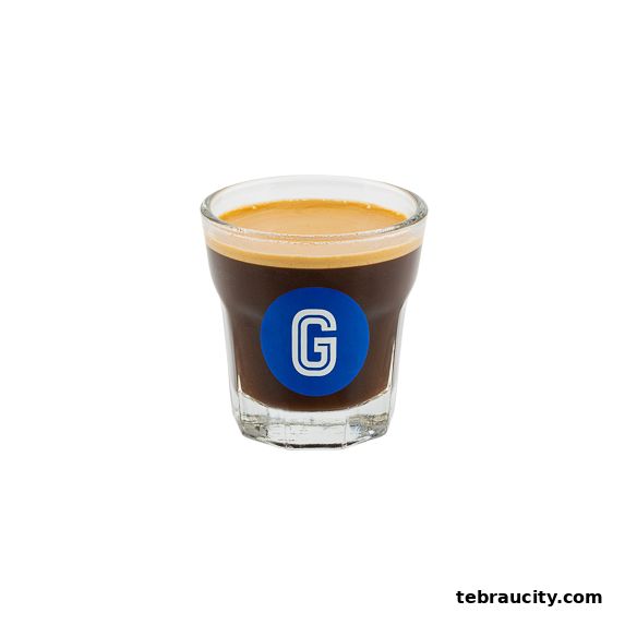 A shot of espresso with a blue circle logo featuring the letter G.