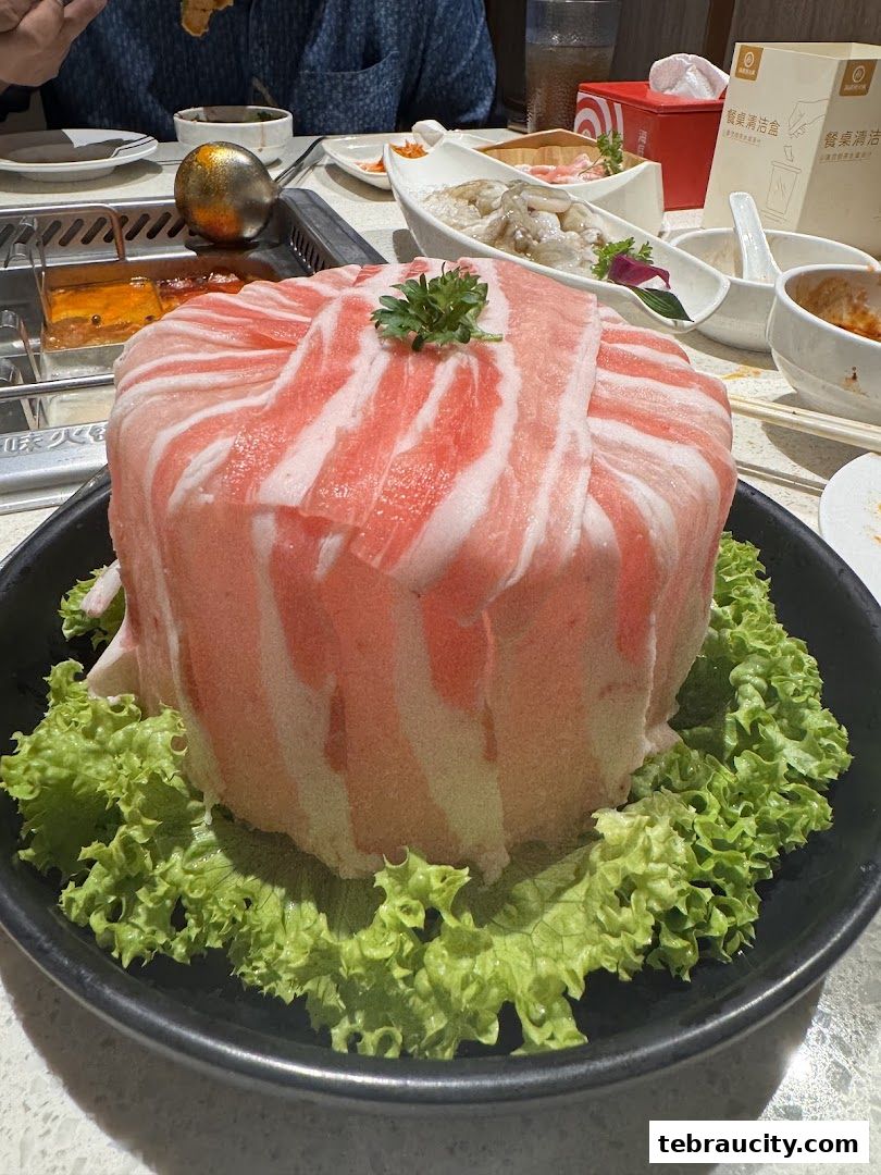 A beautifully presented tower of thinly sliced pork belly for hot pot, garnished with parsley.