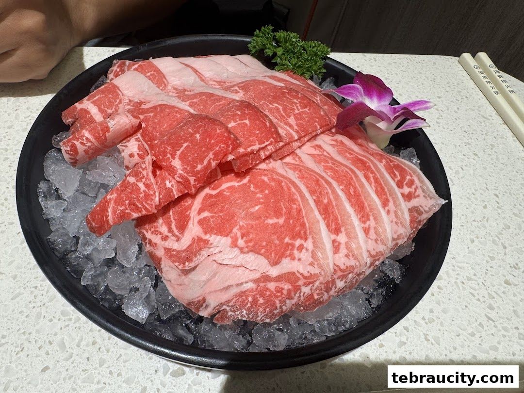A plate of thinly sliced raw beef on ice, garnished with a purple orchid and parsley.