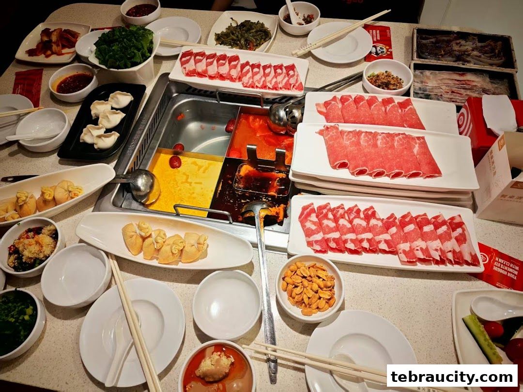 A table laden with various hot pot ingredients, including thinly sliced meats, dumplings, and dipping sauces.