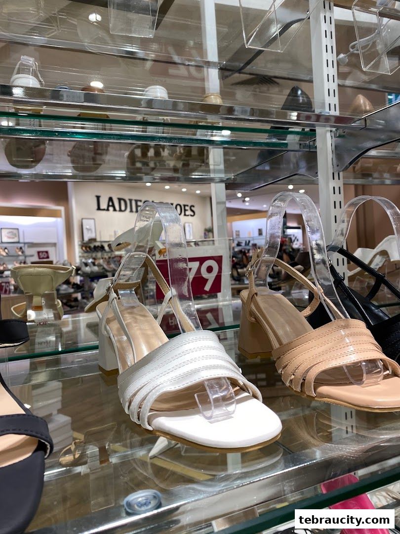 A display of stylish women's sandals on shelves, featuring white and tan options.