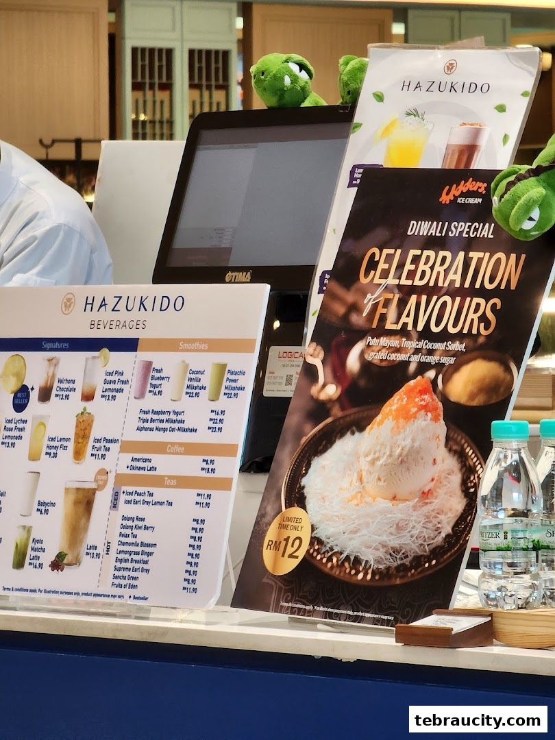 A display counter at Hazu Bakery Cafe with various beverages and a special Diwali dessert.
