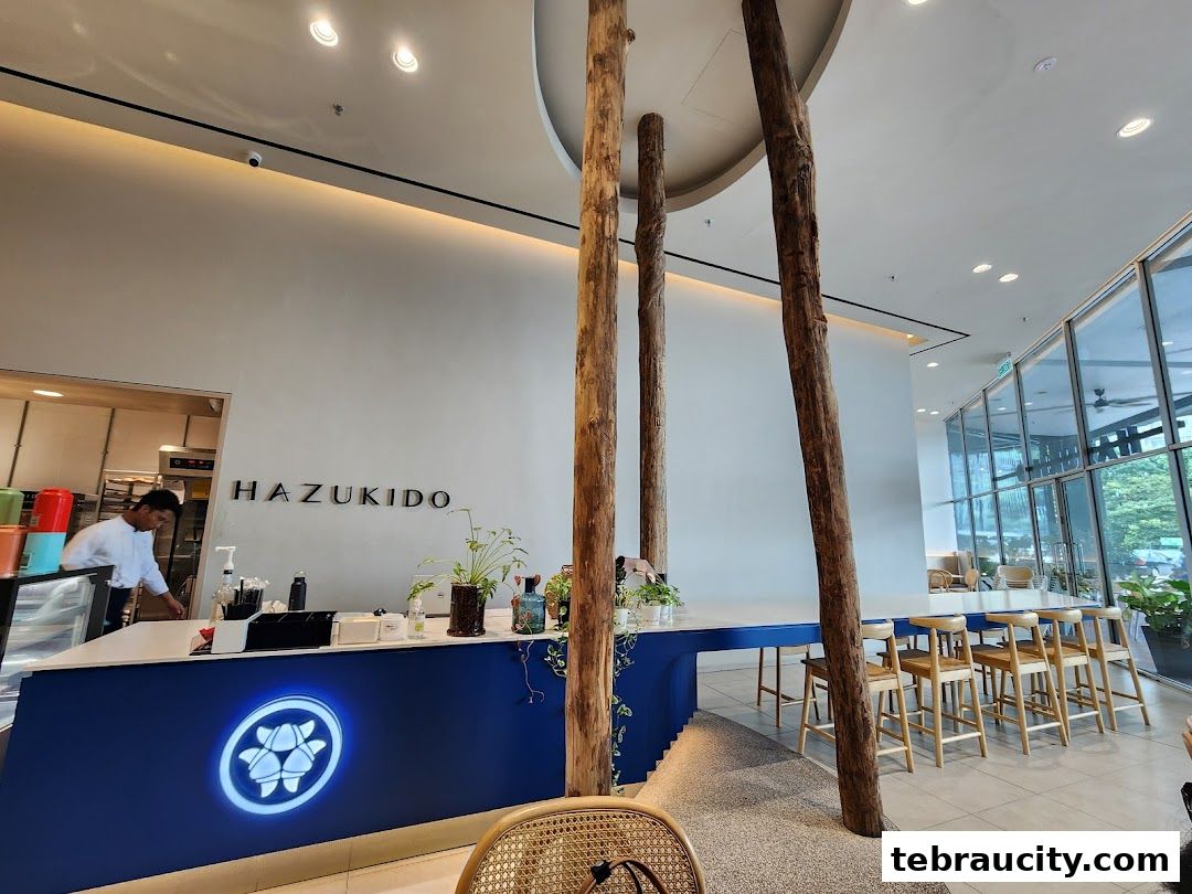 Interior of Hazu Bakery Cafe with a counter, seating, and natural wood pillars.