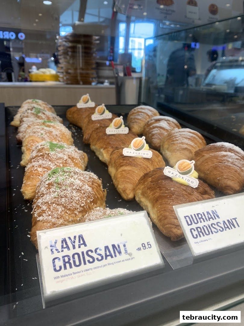A display of freshly baked croissants, including Kaya and Durian flavors.