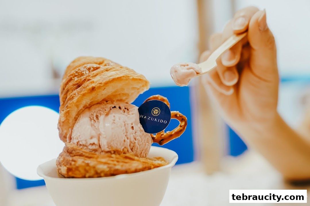 A close-up of a croissant ice cream dessert with a spoon taking a bite.