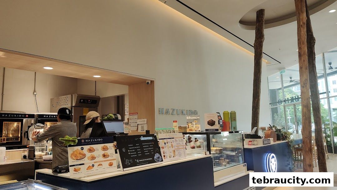 Interior view of Hazu Bakery Cafe with a counter, display cases, and seating area.