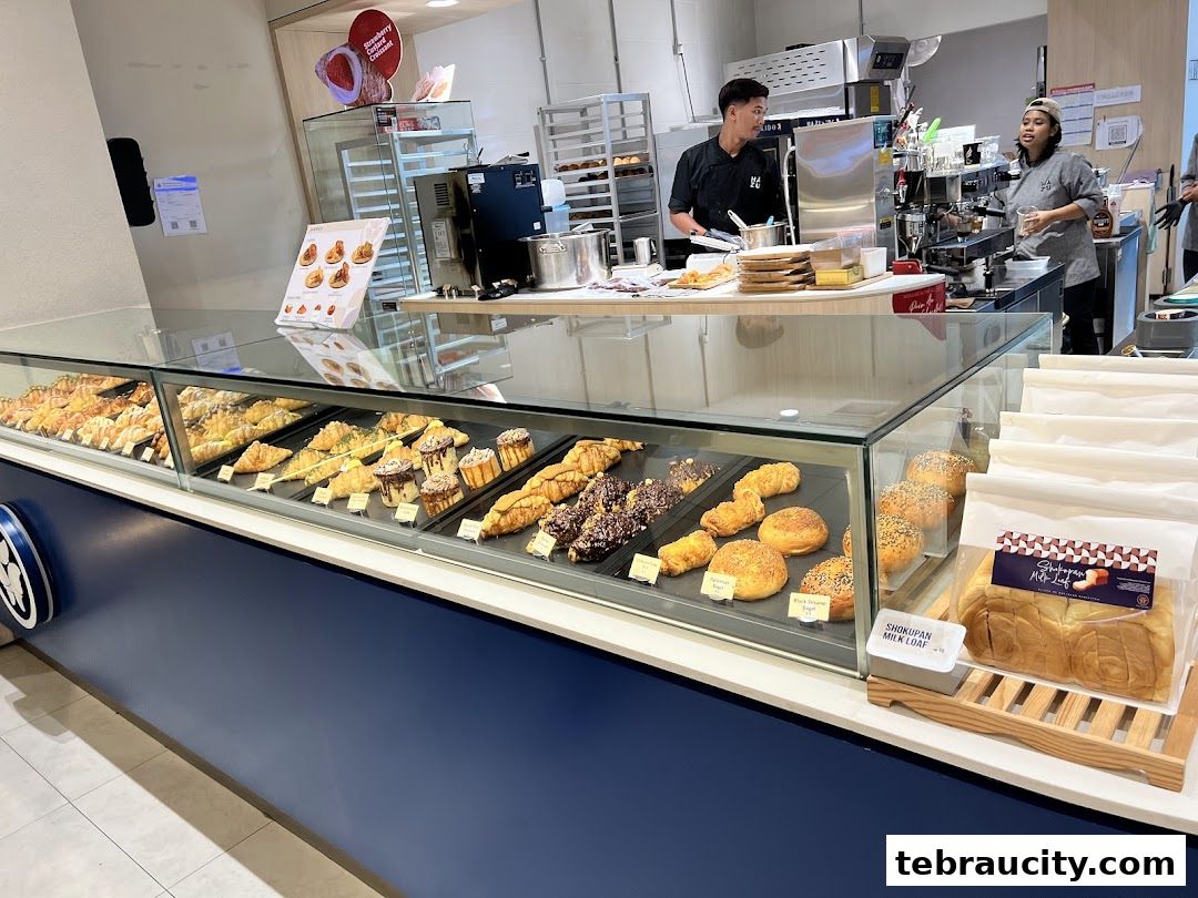 A display case filled with various pastries and breads at Hazu Bakery Cafe.