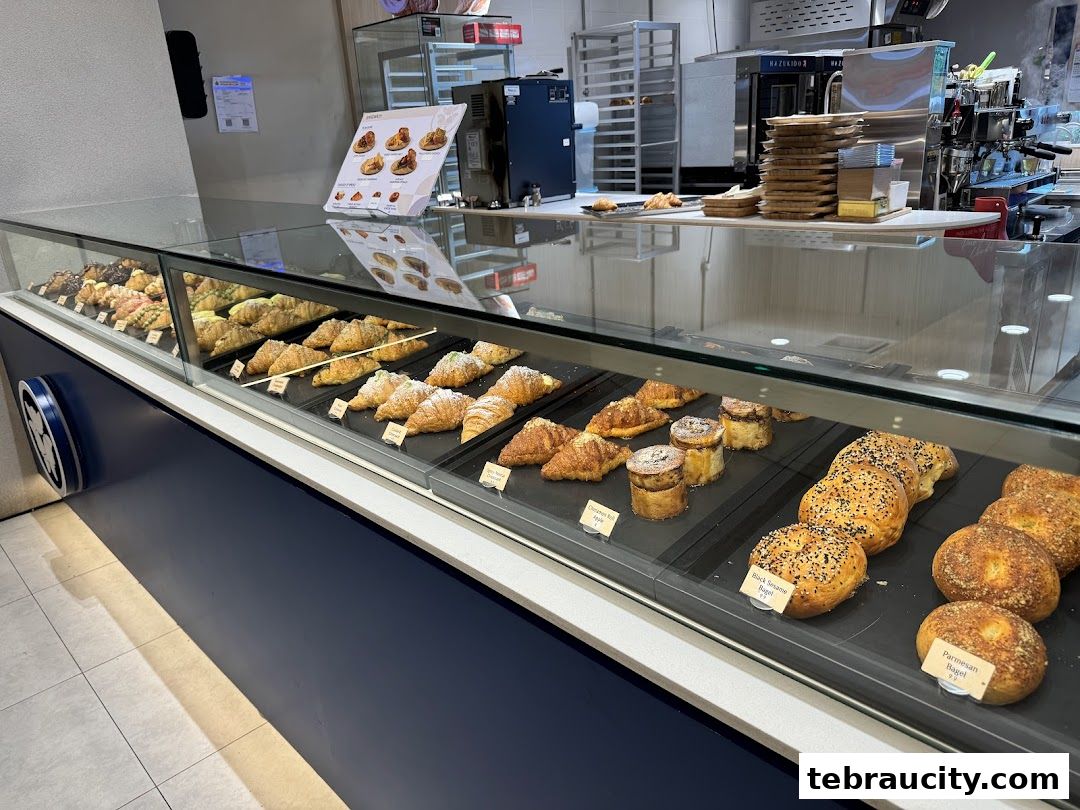 A display case filled with a variety of freshly baked pastries and breads at Hazu Bakery Cafe.