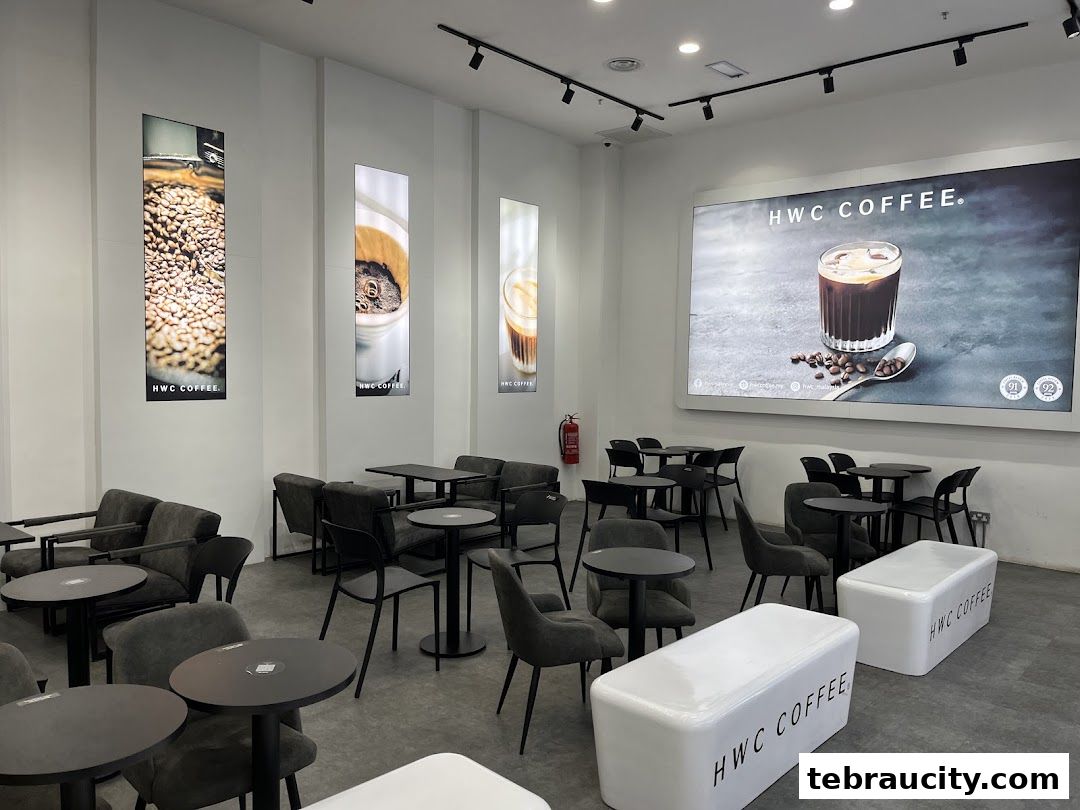 Interior of HWC Coffee shop with seating, tables, and large promotional displays.