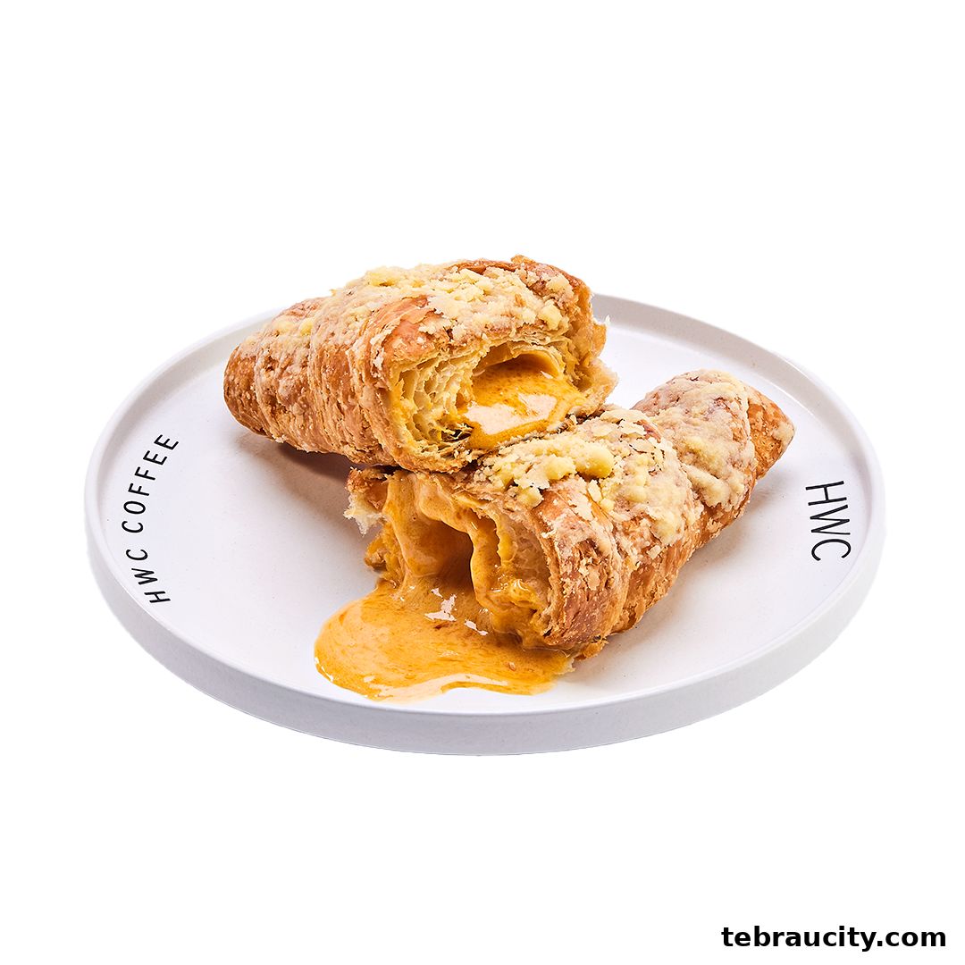 A delicious-looking croissant filled with creamy cheese, served on a white plate.