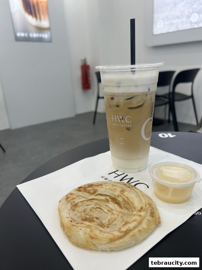 A close-up of a layered pastry and a creamy iced coffee drink on a table.