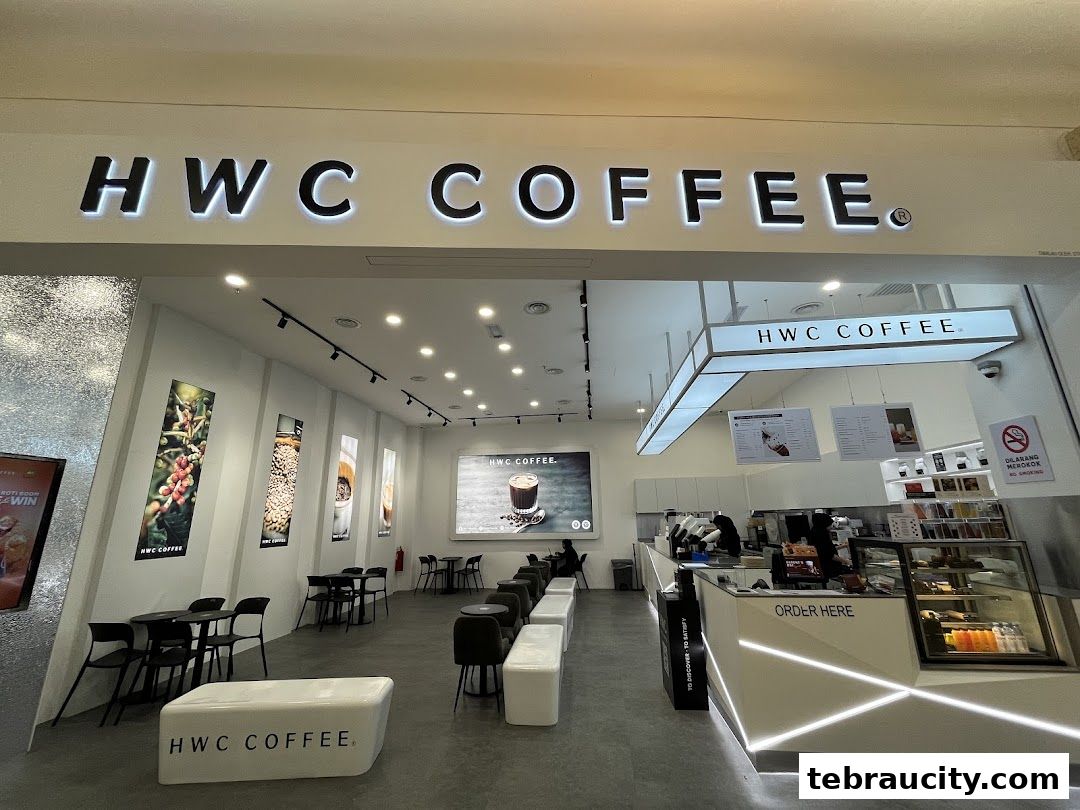 The modern interior of HWC Coffee with seating, a counter, and illuminated signage.