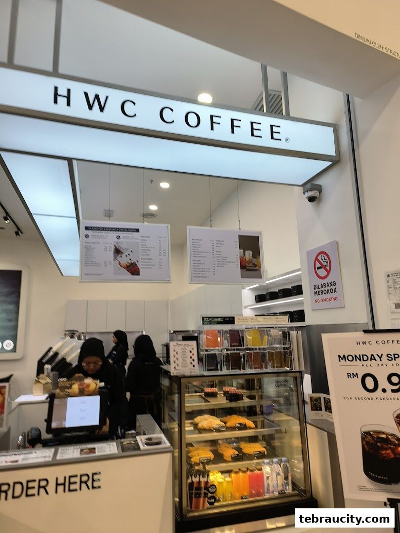 The entrance of HWC Coffee shop with a prominent sign and display of food and drinks.