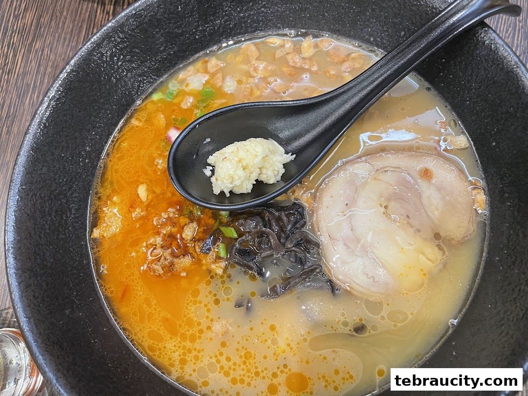 A close-up shot of a steaming bowl of ramen with rich broth, chashu pork, and toppings.