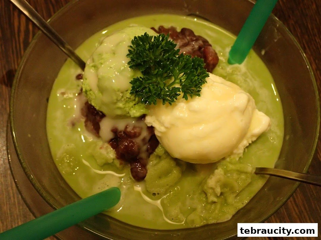 A refreshing green dessert with ice cream, red beans, and a parsley garnish.