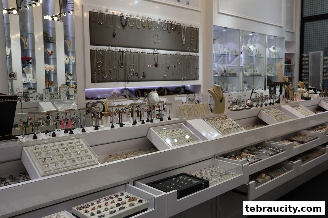 Interior view of a well-lit jewelry store showcasing a wide variety of necklaces, earrings, and rings.