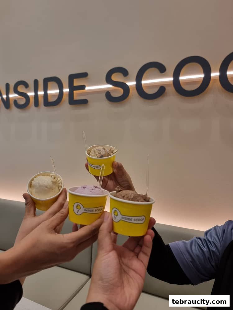 Four cups of ice cream are held up in a toast, with the shop's logo visible.