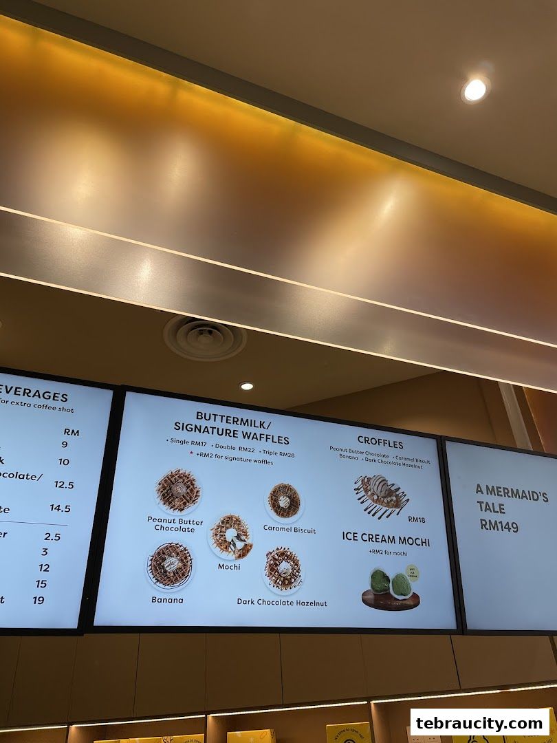 A digital menu board displaying various waffles, croffles, and ice cream mochi with prices.